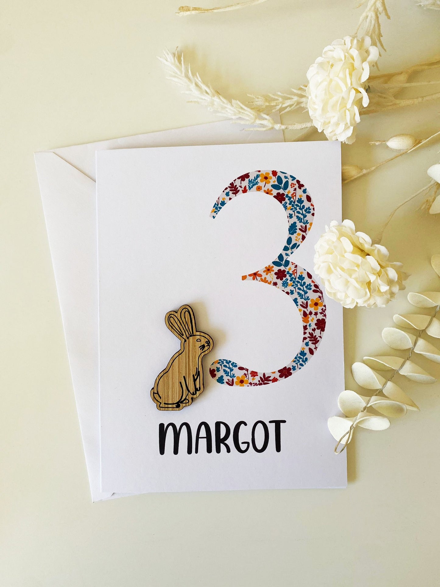 Celebrate a 1st birthday with our Personalized Card featuring a charming wooden charm. Perfect for a unique and heartfelt gesture.